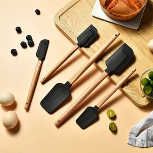 Detailansicht von fünf Silikonspateln mit ergonomischen Holzgriffen zum Backen