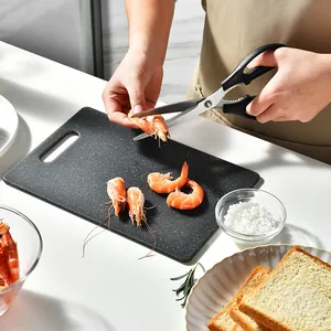 Durable black marble pattern plastic cutting board being used for seafood preparation