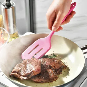 Pink heat resistant silicone slotted spatula turner for cooking steaks in a non-stick pan
