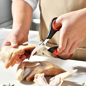 Gebogene Küchenschere aus Edelstahl zum Schneiden von rohem Geflügel auf einem Brett