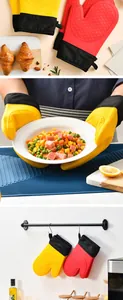 Guantes de silicona resistentes al calor sosteniendo un plato caliente y colgados en estante