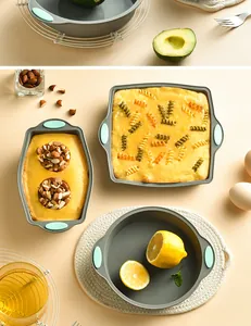 Variety of non-stick gray silicone baking molds with food and ingredients on a table.