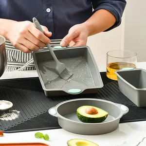 Non-stick silicone baking mold set with square and round cake pans and a pastry brush.