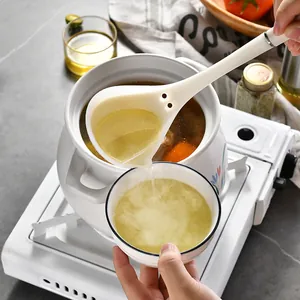 Translucent white silicone ladle with ergonomic handle pouring soup in kitchen setting