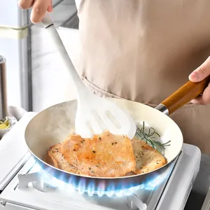 Premium semi-transparent silicone spatula with long handle cooking meat in a frying pan