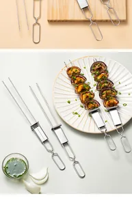 Detail of dual-prong stainless steel BBQ skewers with pusher handle on a plate