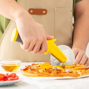 Stainless steel pizza wheel cutter with ergonomic yellow handle slicing fresh pizza