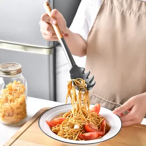 Heat resistant silicone pasta server with natural wood handle used for serving spaghetti