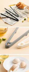 Detail view of heat-resistant silicone food tongs picking up a fresh egg on a white plate.