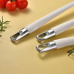 White silicone kitchen utensil handles with chrome plated hanging loops on yellow background