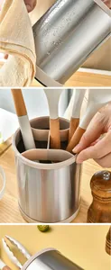 Close-up of stainless steel kitchen utensil holder showing four divided compartments.