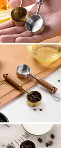 Detail view of 14ml stainless steel measuring spoons with wooden handles and hanging chains.
