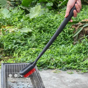 Professional long-handled BBQ grill cleaning brush with integrated scraper and red nylon bristles