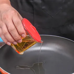 Clear kitchen oil dispenser pot with red silicone lid and eagle beak for precise pouring