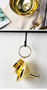 Detailed view of gold plated stainless steel funnel set hanging on a kitchen hook