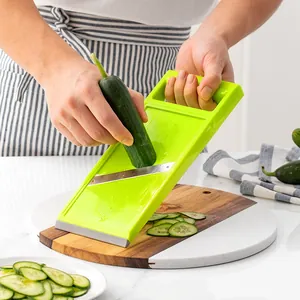 Ergonomic handheld vegetable slicer for cucumber slices on marble cutting board