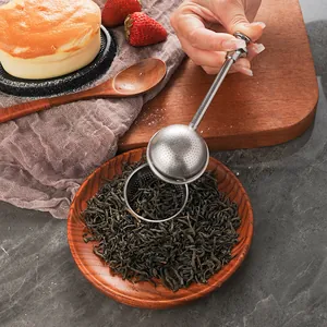 304 stainless steel retractable tea infuser ball held over loose leaves in a home setting