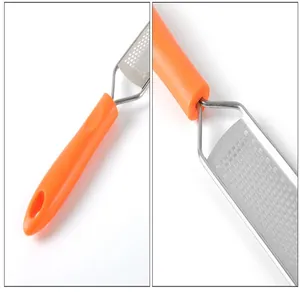 Vue détaillée d'une râpe à fromage en acier inoxydable avec poignée orange ergonomique