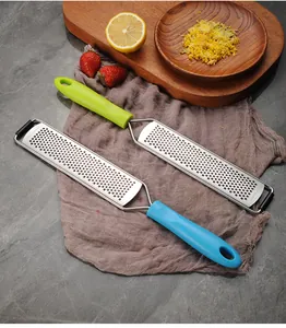Zesteurs à citron et râpes à fromage en inox avec poignées colorées dans une cuisine rustique