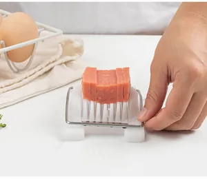 Primo piano di un affettatore multifunzionale in acciaio per carne su tavolo bianco