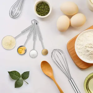 Gros plan de cuillères à mesurer et d'un fouet en inox dans une scène de cuisine
