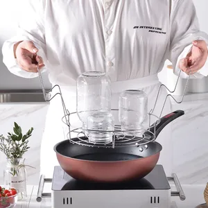 Stainless steel canning rack lifter for jam jars shown with cooking pot in kitchen
