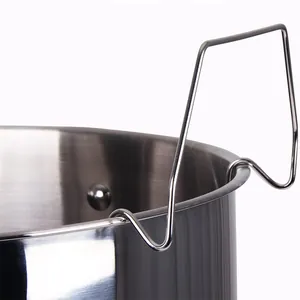 Detail of a durable stainless steel canning rack hook resting on a kitchen pot rim