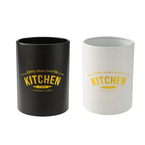 Modern matte black and white kitchen utensil storage canisters with gold decorative text