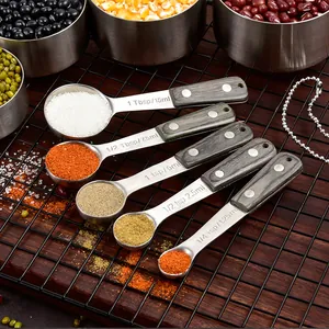 Stainless steel measuring spoon set with grey wood handles and engraved measurements