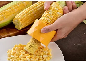 Detailed view of yellow geometric corn stripper removing kernels from a fresh cob