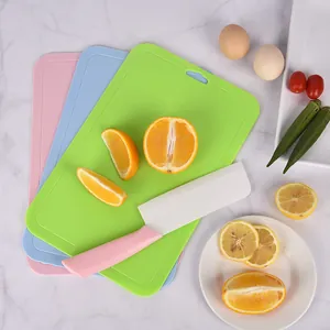 Set of 3 colorful plastic cutting boards with ceramic knife and fresh fruit