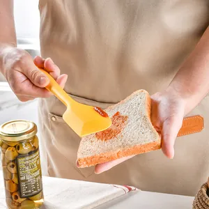 Ergonomic yellow silicone spatula for spreading jam on bread in a kitchen setting