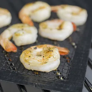 Reusable non-stick fiberglass BBQ grill mesh mat with delicious grilled shrimp on rack