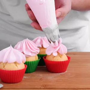 Large 304 stainless steel Russian piping tip decorating cupcakes with pink cream frosting.