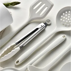 Juego de utensilios de cocina de silicona blanca resistente al calor con espátula y cazo.