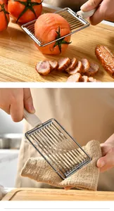 Detailed view of the stainless steel kitchen slicer cutting tomato and ham slices.