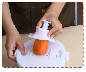 Detailed view of using the safety hand guard to slice a carrot on the vegetable grater