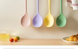 Quatre cuillères à soupe en silicone colorées accrochées dans une cuisine moderne.