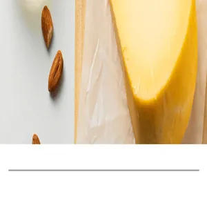 Macro shot of yellow cheese and almonds on parchment paper for kitchen slicer.