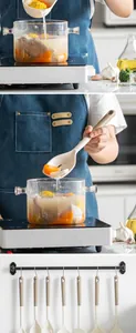 Set of heat-resistant silicone kitchen utensils in use and hanging storage.