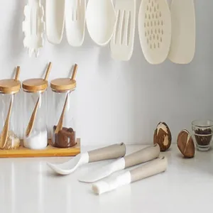 Detail view of white and beige silicone kitchen utensils set in a bright kitchen scene
