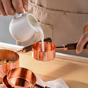 Professional rose gold stainless steel measuring cup with acacia wood handle for baking
