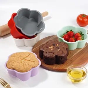 Flower-shaped silicone cake molds in assorted colors with freshly baked cakes