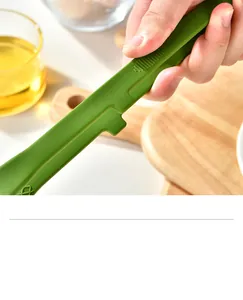 Close-up of integrated green silicone food tong showing the anti-slip grip texture