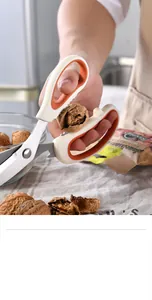 Dettaglio di forbici da cucina multifunzione utilizzate per rompere facilmente una noce.