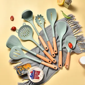 8-piece heat resistant silicone kitchen utensil set with natural wooden handles in mint green
