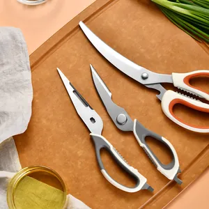 Set of three stainless steel kitchen scissors on a wooden board for diverse food prep