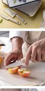 Person cutting an apple on a beige folding cutting board with a small paring knife