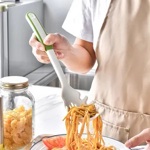 Heat-resistant silicone spaghetti server spoon lifting pasta in a modern kitchen