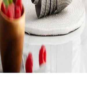Close-up detail of professional stainless steel measuring cups on a white woven mat